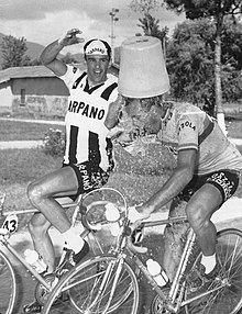 A cyclist pouring water on another.