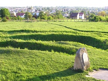 Memorial plaque and trenches covered by grass