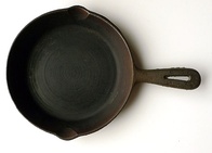 A painted cast iron decorative grate (l) and cast iron cooking skillet (r)