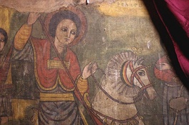 The Church of Saint George, Lalibela and a panel painting inside depicting Saint George slaying a dragon; it is one of eleven monumental rock-hewn churches built in Lalibela, Ethiopia that were allegedly sculpted after a vision by the Zagwe-dynasty ruler Gebre Mesqel Lalibela (r. 1185–1225 AD), in which St George instructed him to do so.[38] The city of Lalibela was reestablished as a symbolic new holy site, following the fall of Jerusalem to the Muslim forces of Saladin in 1187 AD, yet archaeology reveals the religious structures to have been built between the 10th and early 12th centuries AD, with perhaps only the last phase carried out during the 13th century AD and reign of Gebre Mesqel Lalibela.[39]