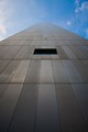 The Federal Reserve Bank of Boston viewed from the side at street level. The entire building is covered with a matte aluminum paneling.