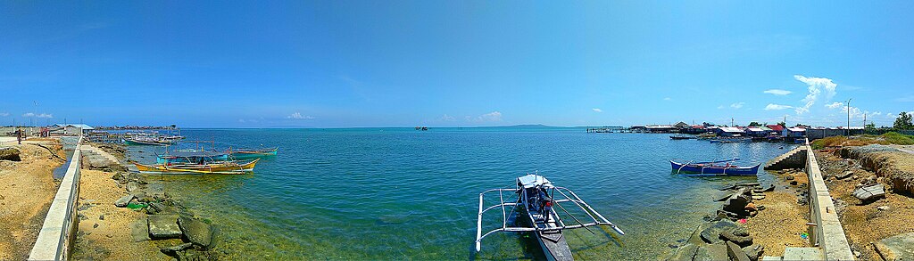  View of Leyte Gulf facing southwest from the Guiuan Integrated Transport Terminal in 2019, showing the islands of Homonhon (left, nearly invisible due to haze), Manicani (near center), and Inatunglan (to the immediate right of Manicani)