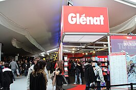 The Glénat booth at the 2013 Angoulême comics festival with on the right one of its most important early artists, François Bourgeon (2014), whose heroine Isa from Les Passagers du vent was exemplary of the new historical realism in Franco-Belgian comics