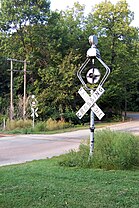 Two examples of WRRS Autoflag #5 "center harp" wigwag signals, (left): on a CN&W crossing in Wisconsin, July 1982. (right): on Devil's Lake, Wisconsin, September 2005. These signals were retired in 2012.