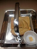 Sacrament trays containing bread and water. The bread is broken and the trays are blessed and passed to the congregation.