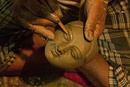 From top left to bottom right (a) A craftsperson sculpting the face of the sculpture-idol; (b) Durga Puja pandal decorations in Kolkata; (c) Interior decorations of a pandal; (d) Street lights installed during the festivities.