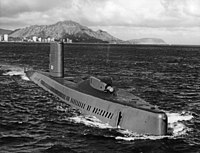 A submarine at sea with a mountain in the background