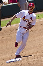 Stan Musial wearing the Cardinals' 1950s road uniform with the original navy cap and red bill.