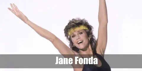  Jane Fonda’s costume is high-waist gray purple leggings, a one-piece 80s vintage thong bathing suit, blue 80s workout leg warmers, a purple skinny belt, and a blue workout headband.