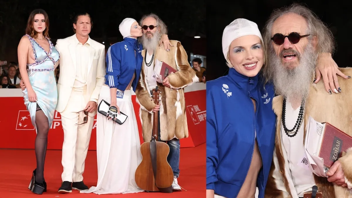 Wearing a white swim cap and blue Adidas jacket, Julia Fox smiles with director Tony Kaye, co-star Bella Thorne, and co-star Vito Schnabel at 'The Trainer' premiere