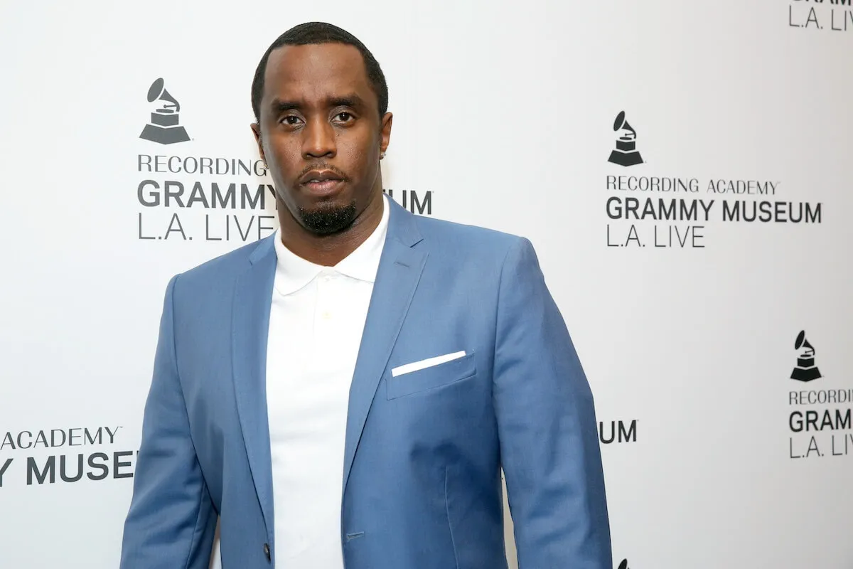 Sean 'Diddy' Combs wears a blue suit and stands in front of a white background.