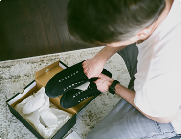 man holding new shows over an opened shoebox