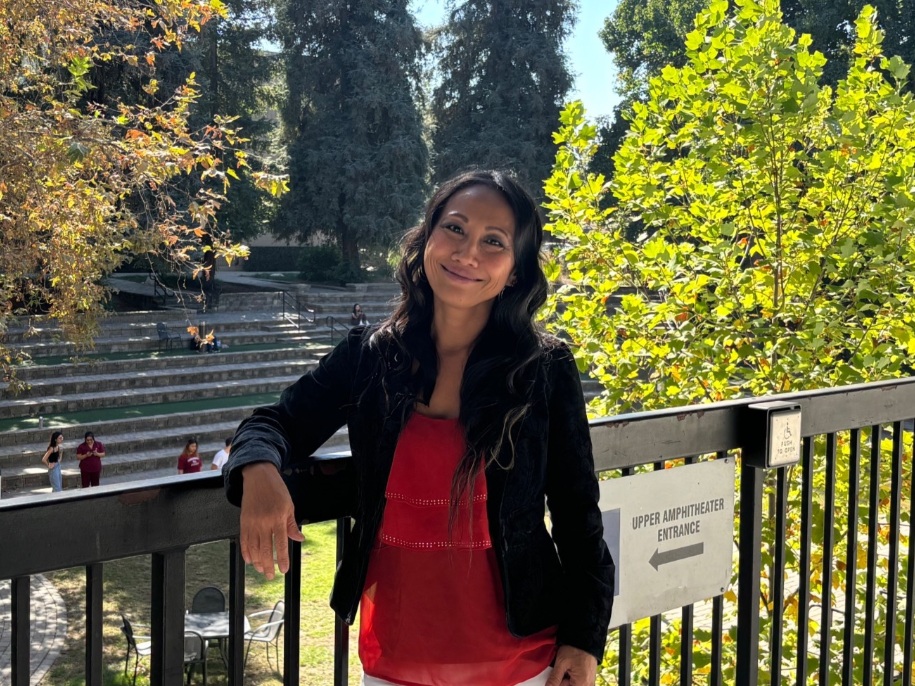 charity smiles outside the amphitheater on east campus on a sunny day