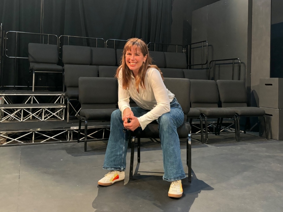 kirsten smiles while sitting backstage in apu's blackbox theater