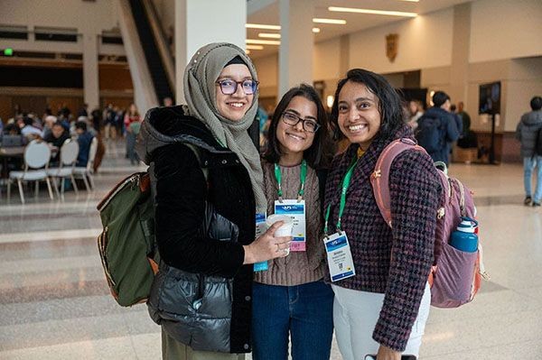 Three APS members pose for photo at a conference.