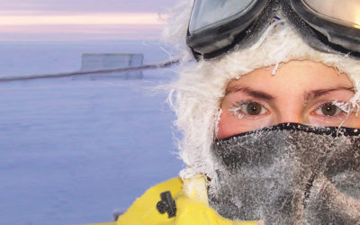 The face of a woman wearing cold weather clothing in an icy landscape