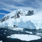 Ocean with floating sea ice, with a snowy mountain in the background