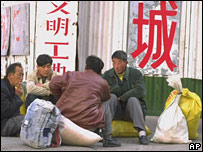 Migrant workers rest on a Beijing street on Sunday Febuary 27, 2000. China Daily newspaper reported that last year only 22 million out of the 70 million unemployed rural laborers who went to cities found work. Chinese leaders worried that frequent protest