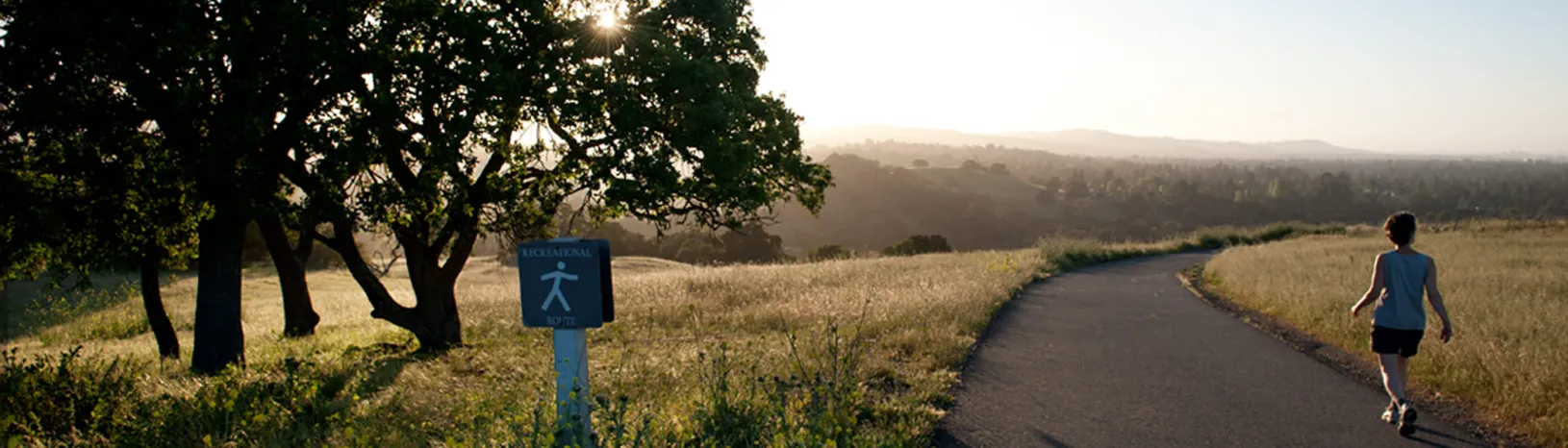 Woman walking on The Dish trail at sunset