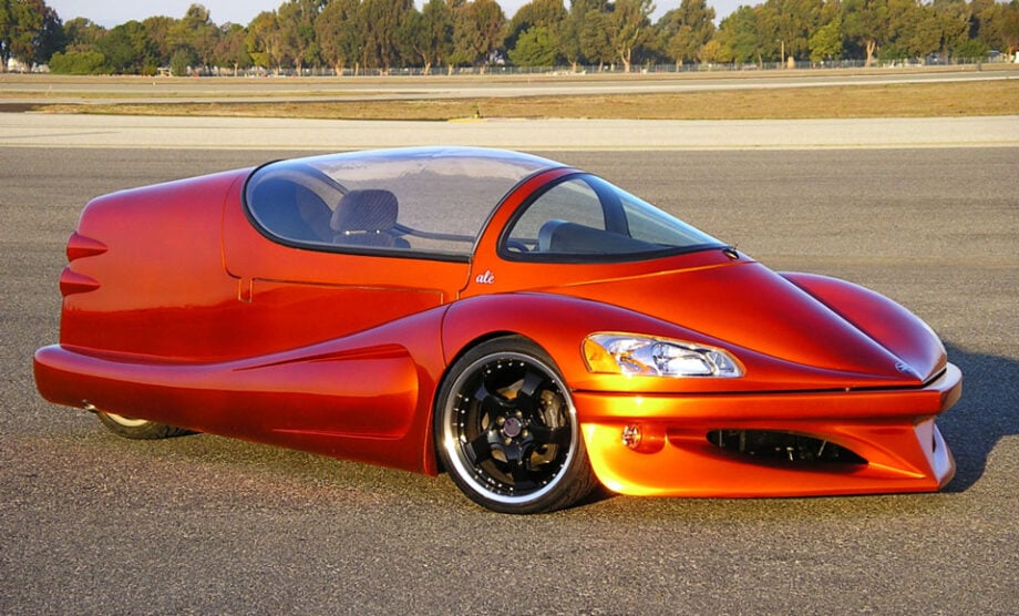 Custom-built orange three-wheeler parked.