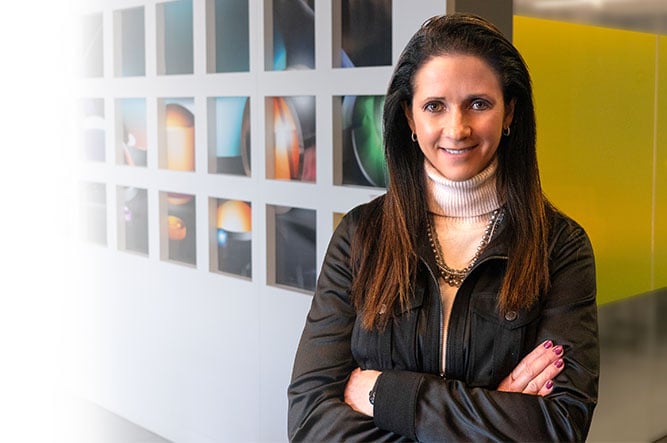 Marisa Edmund standing in an an Edmund Optics facility with her arms crossed