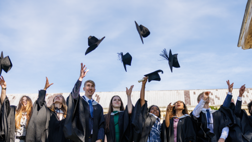 Students throwing graduation caps in the air