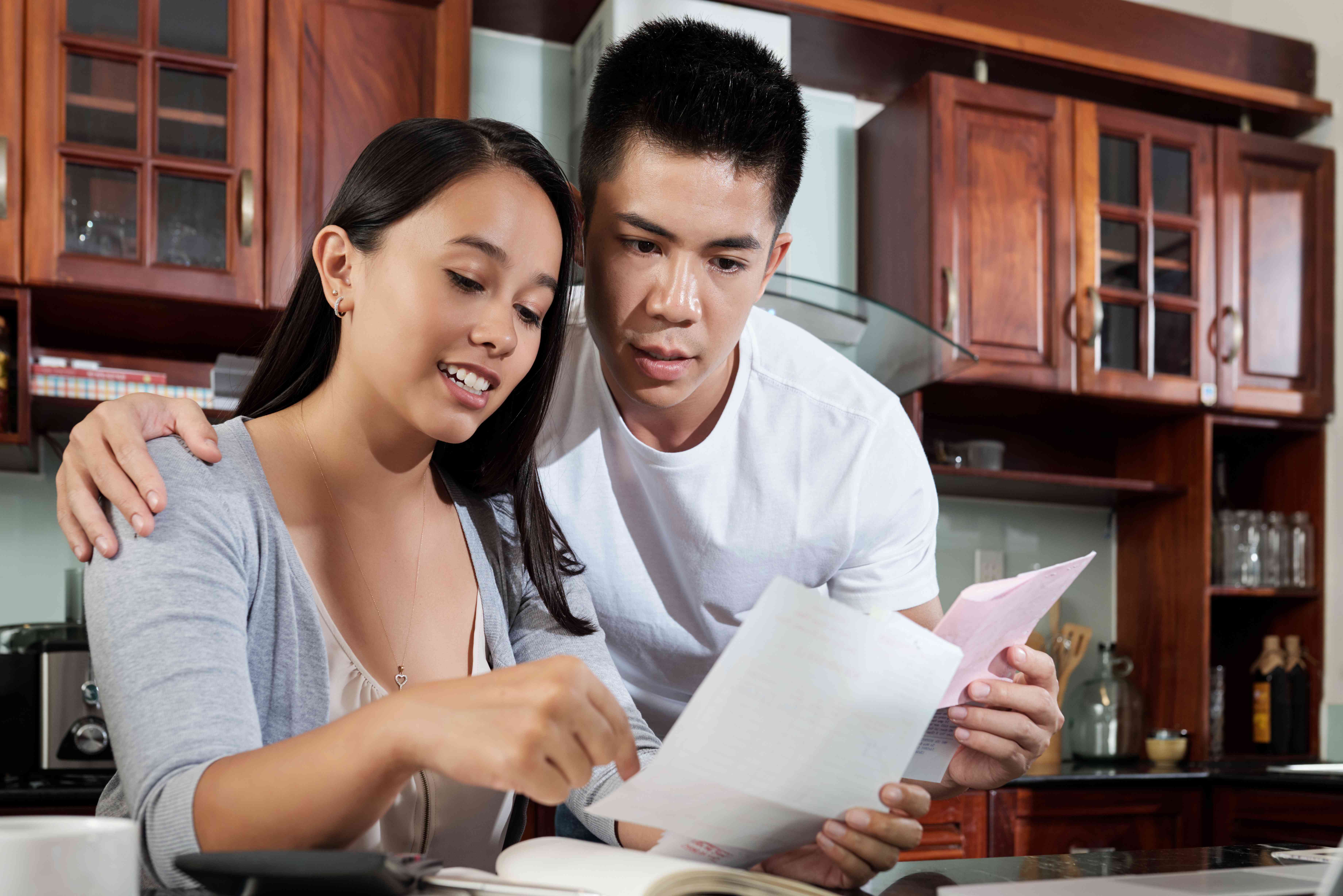 Young Asian couple checking their bills