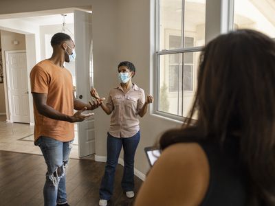 An African American couple tour for a house with a real estate agent during the COVID-19 pandemic