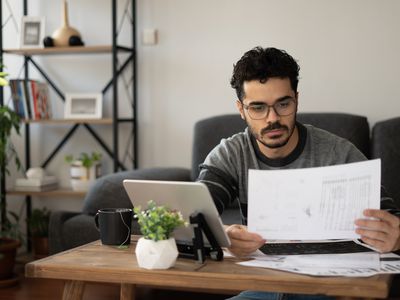 A man reviews documents at a home desk.