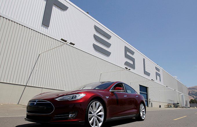 The Tesla building facade with a Model S in front.