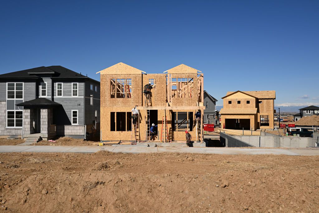 Construction crews work to build new homes in a subdivision by Tri Pointe Homes Colorado in Aurora Highlands, Colorado on April 8, 2024. 