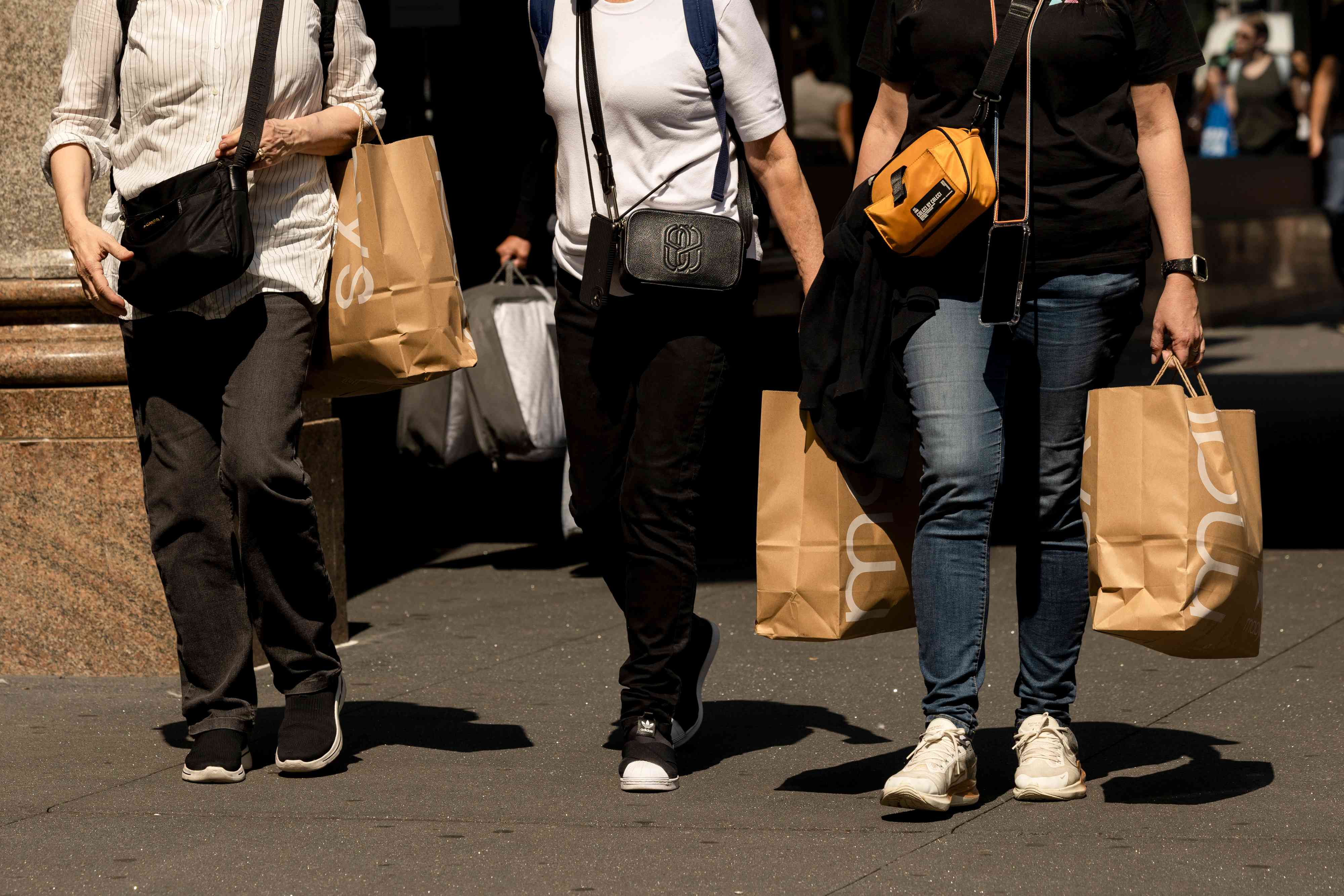 Shoppers carry Macy's bags outside the company's flagship store in New York, on Sept. 13, 2024