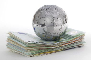 A ball made out of puzzle pieces placed on a stack of Euros.