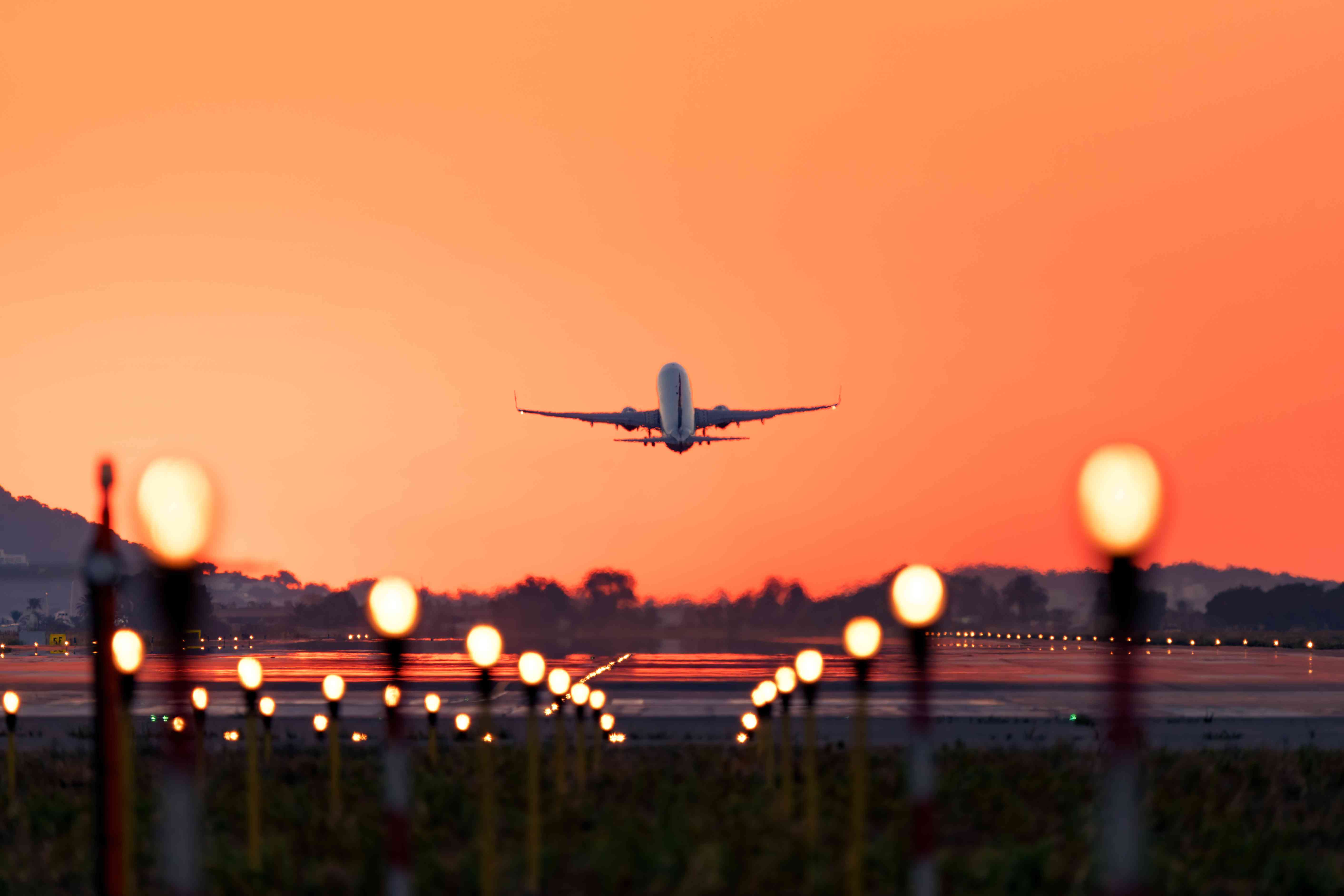 Airplane taking off at sunrise