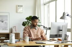 Person wearing glasses using desktop computer 