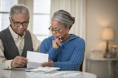 Older couple reviewing paperwork about the reverse mortgage laws.