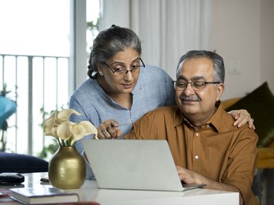 Senior couple looking together at laptop