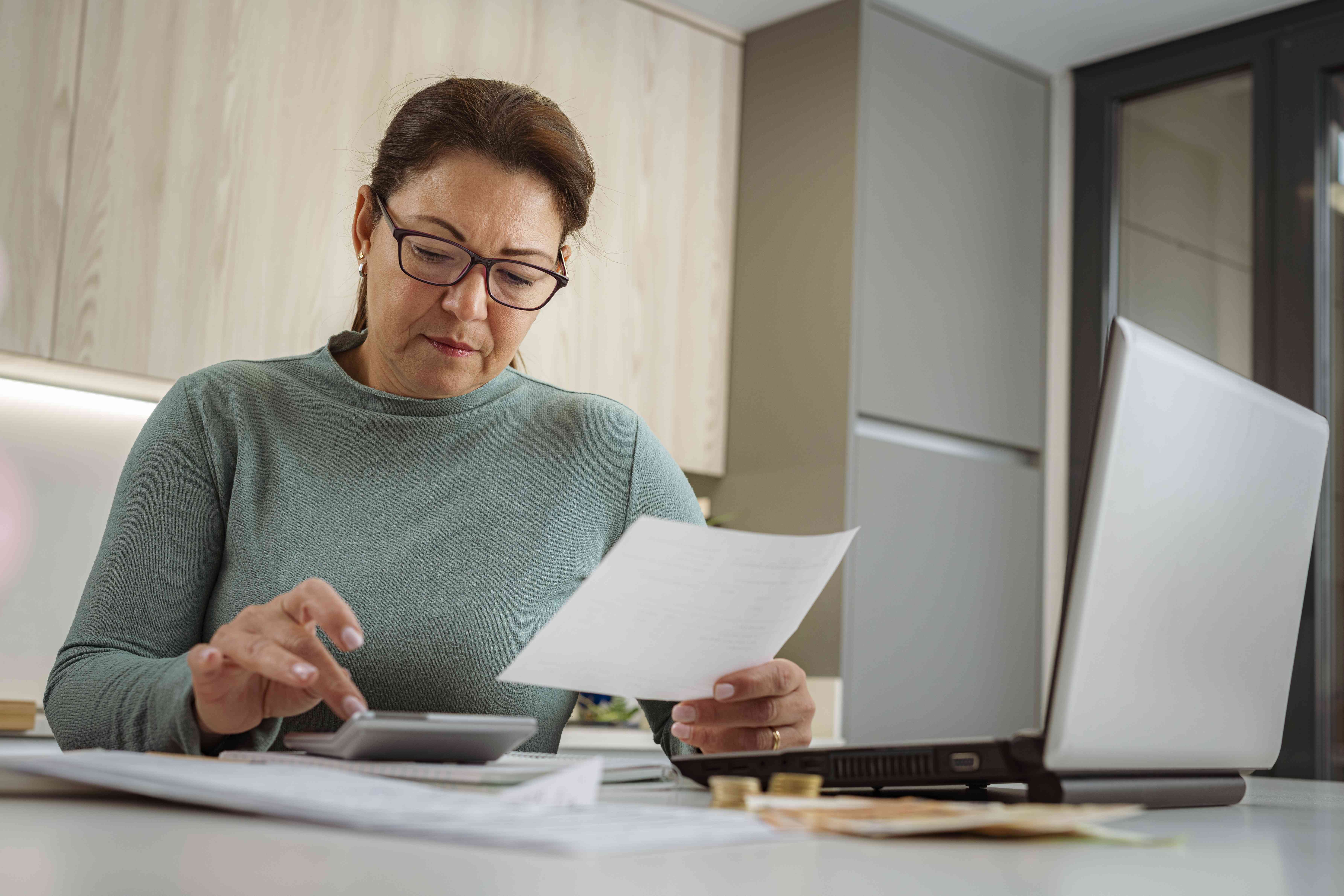 Taxpayer at desk with calculator working on their state taxes.