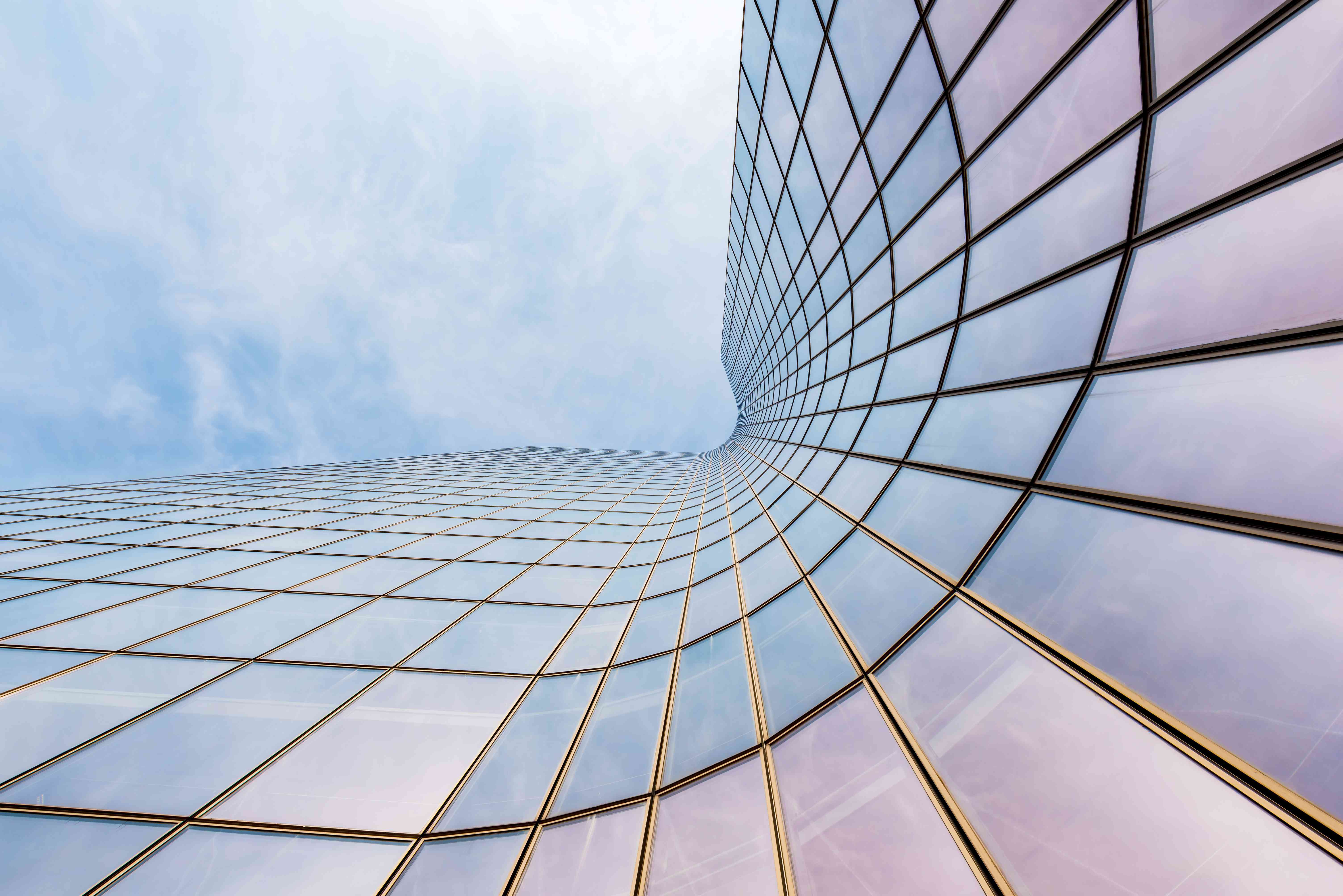 Curved skyscraper against blue sky