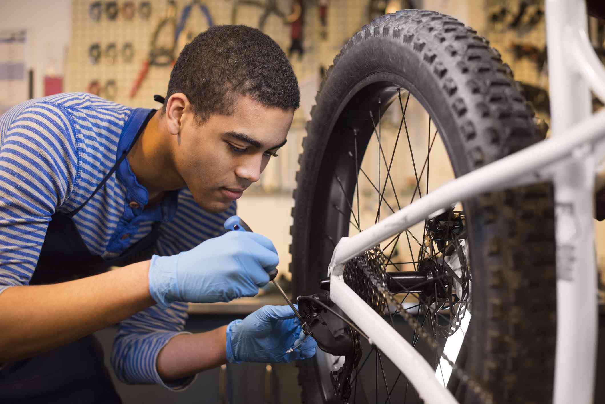 Young mechanic fixing some gears on a bike