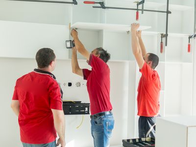 Carpenters fixing new shelves in living room.