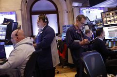 Stock trader Gregory Rowe (R) works on the floor of the New York Stock Exchange during morning trading on February 14, 2024 in New York City. 