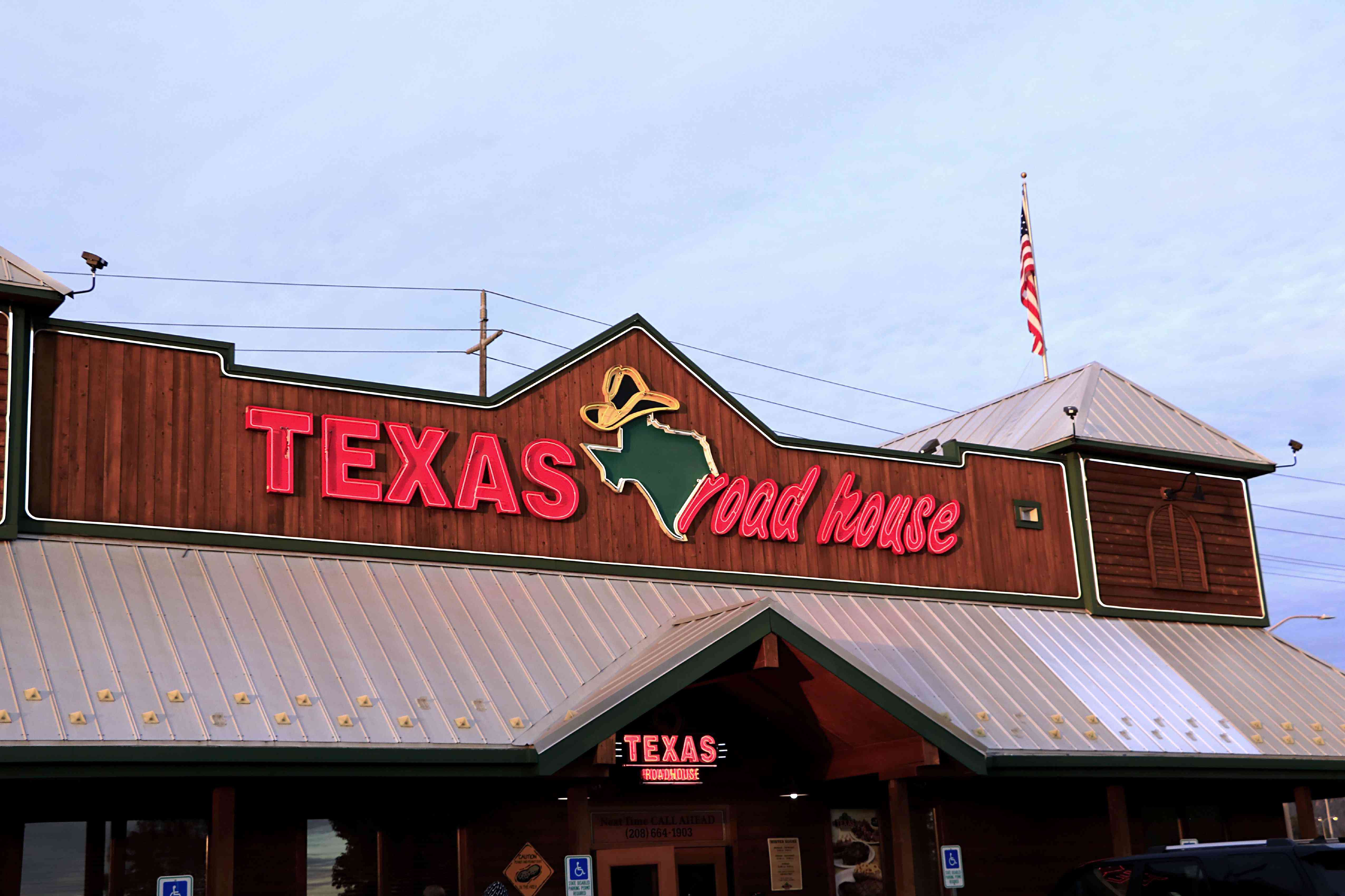 The neon sign at the entrance to a Texas Roadhouse restaurant. 