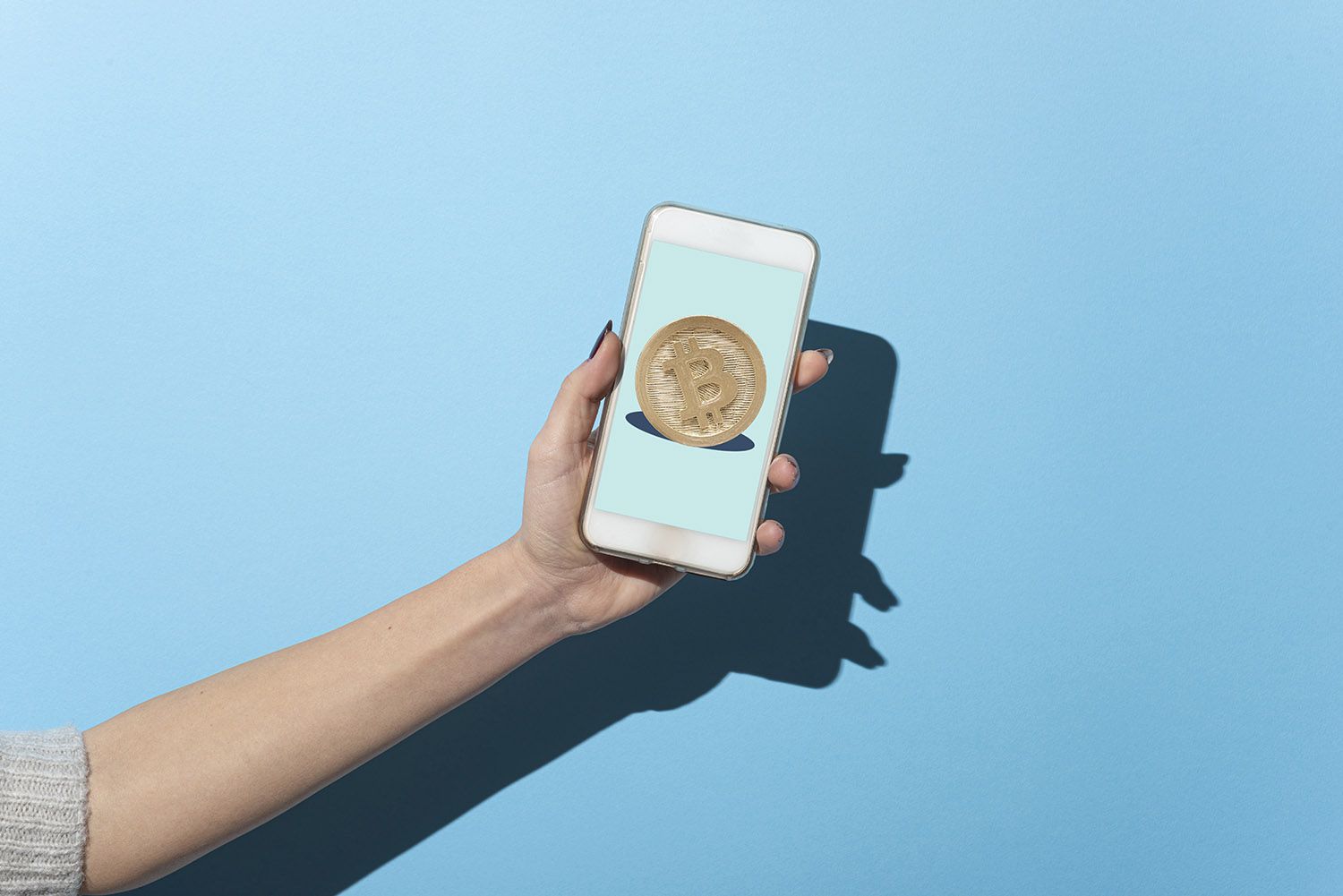 Woman's hand shows her smartphone with Bitcoin