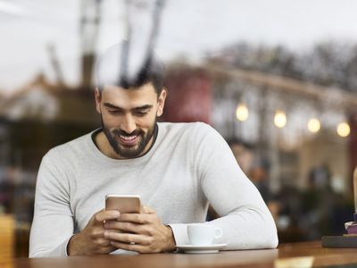 A man uses a cell phone in a cafe.