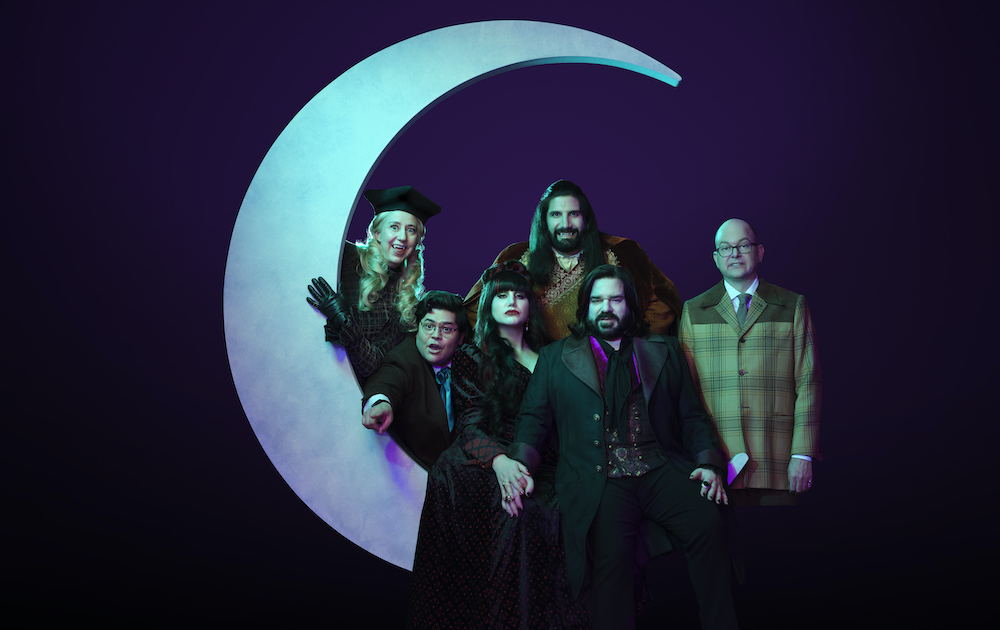 'WHAT WE DO IN THE SHADOWS' Season 5 cast promo: Kristen Schaal, Harvey Guillén, Natasia Demetriou, Kayvan Novak, Matt Berry, and Mark Proksch assembled against a dark background around a large crescent moon.