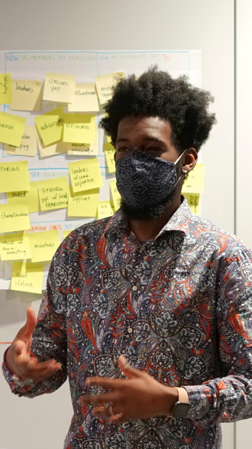 Myself standing in front of a wall of sticky notes with my hands in a gesturing state.