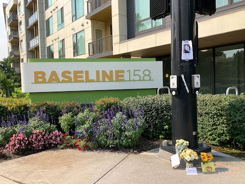 A sign reading "Baseline 128" outside an apartment building.