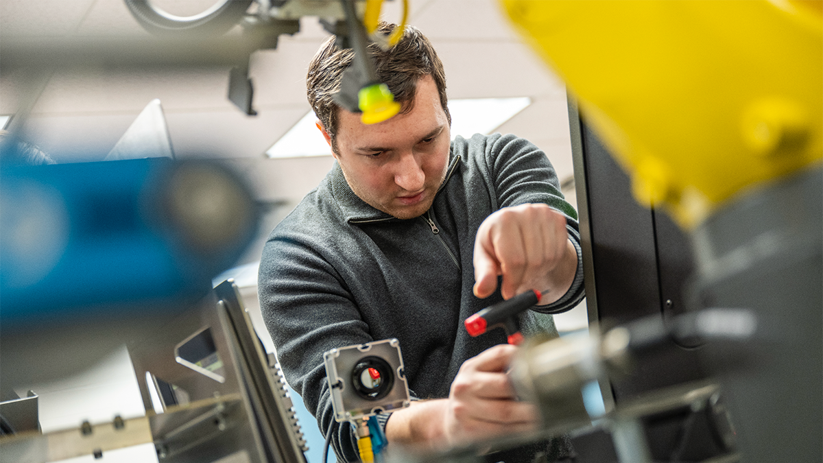 A student works on a piece of engineering equipment