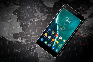 An Android homescreen on a device against a black and white world map